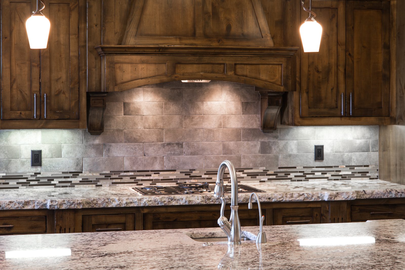 Knotty alder kitchen with custom wood range hood in Central Oregon